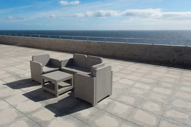 Large-format paver terrace with seating overlooking the sea