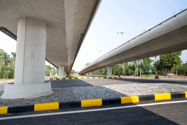 Yellow and black kerb stones lining the road beneath a flyover
