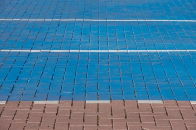 Blue and red interlocking paver blocks on a sports court surface