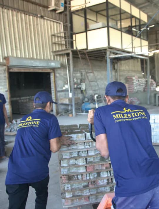 Milestone Cement Products staff stacking finished paver blocks inside the factory